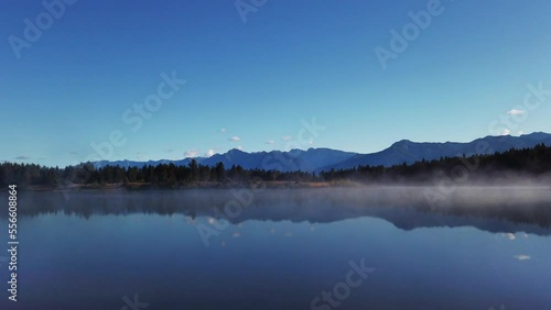 Lake mist with mountains and forest pan Enid British Columbia Canada photo