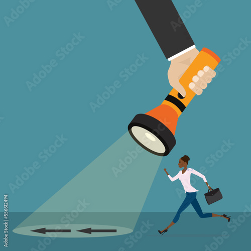 Flashlight in business coach or teacher hand. Beam of light directed on floor and arrow. Handheld electric flashlight illuminate right business way. Businesswoman running in successful path.