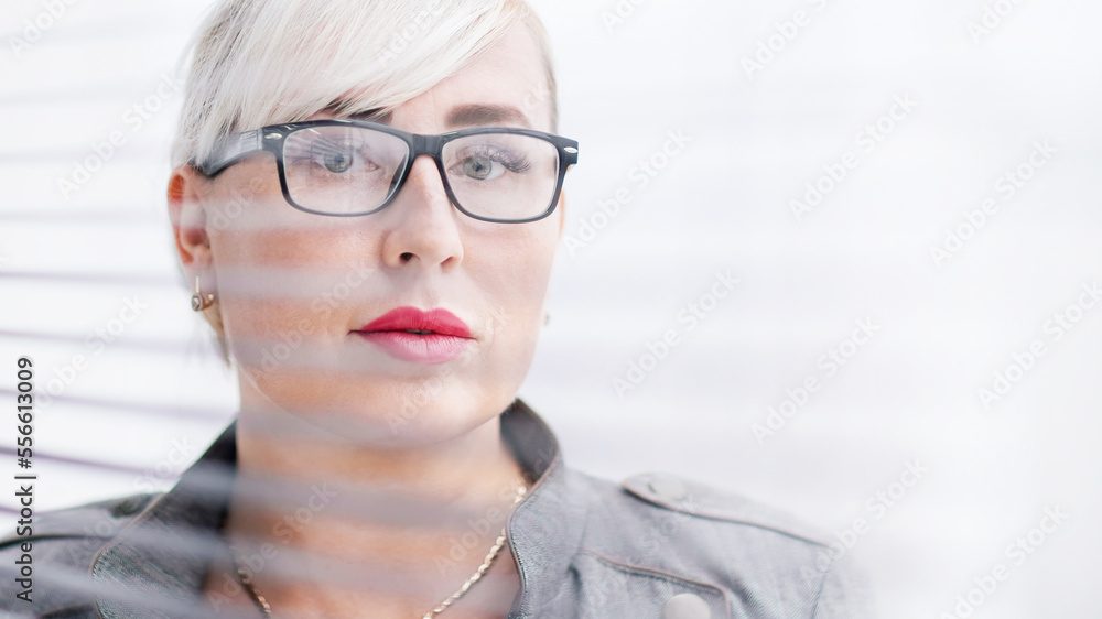 close up. business woman looks somewhere through the office window.