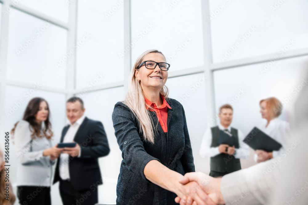 smiling businesswoman shaking hands with her business partner. smiling businesswoman shaking hands with her business partner.