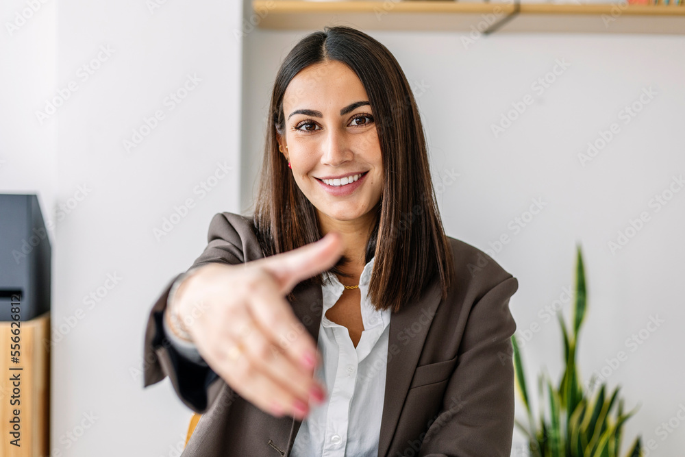 Smiling recruiter making handshake gesture in office Smiling recruiter making handshake gesture in office