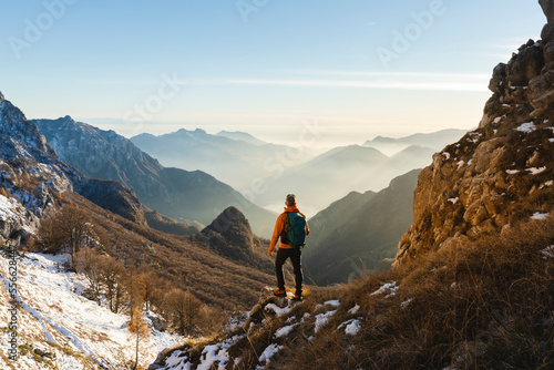 Mature hiker standing in front of mountains photo