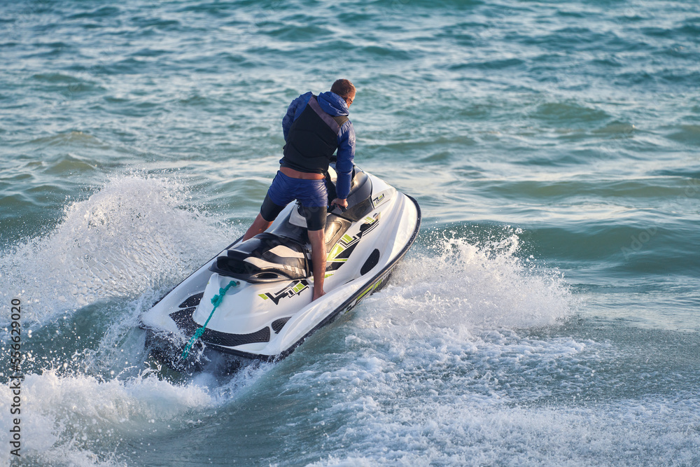 Vacation at the sea. A man accelerates on a water motorcycle. Selective focus. Vacation at the sea. A man accelerates on a water motorcycle. Selective focus.