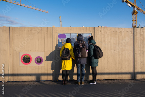 Tourists looking at the panorama of Stockholm through a window in a wooden fence in Stockholm, Sweden