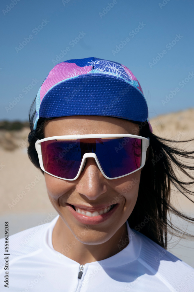 Happy cyclist wearing sunglasses and cap standing on sunny day Happy cyclist wearing sunglasses and cap standing on sunny day