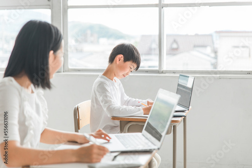 学校・塾のICT教育でパソコンを使って勉強するアジア人の子供（ICT教育・授業・生徒）
