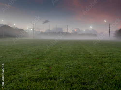 Irish National sport ground wit tall goal posts for camogie, hurling, rugby, Gaelic football at dusk and low fog over the ground. Calm and peaceful mood. Sport activity concept.