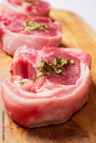 Fresh lamb loin chop with herb on a wooden cutting board. Meat industry product. Butcher craft.