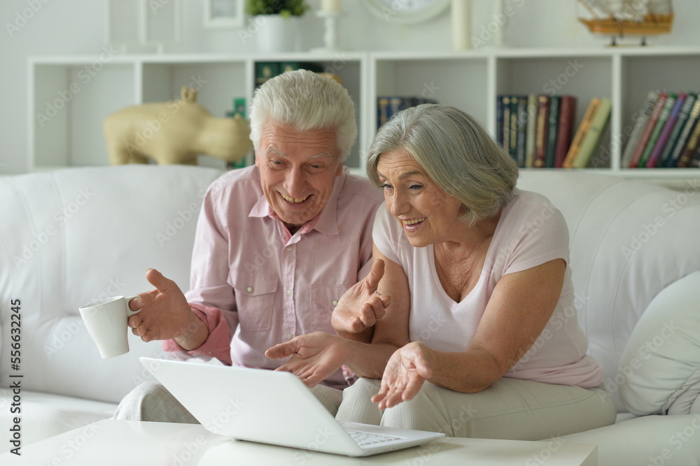 Two old people sitting on couch with laptop Two old people sitting on couch with laptop