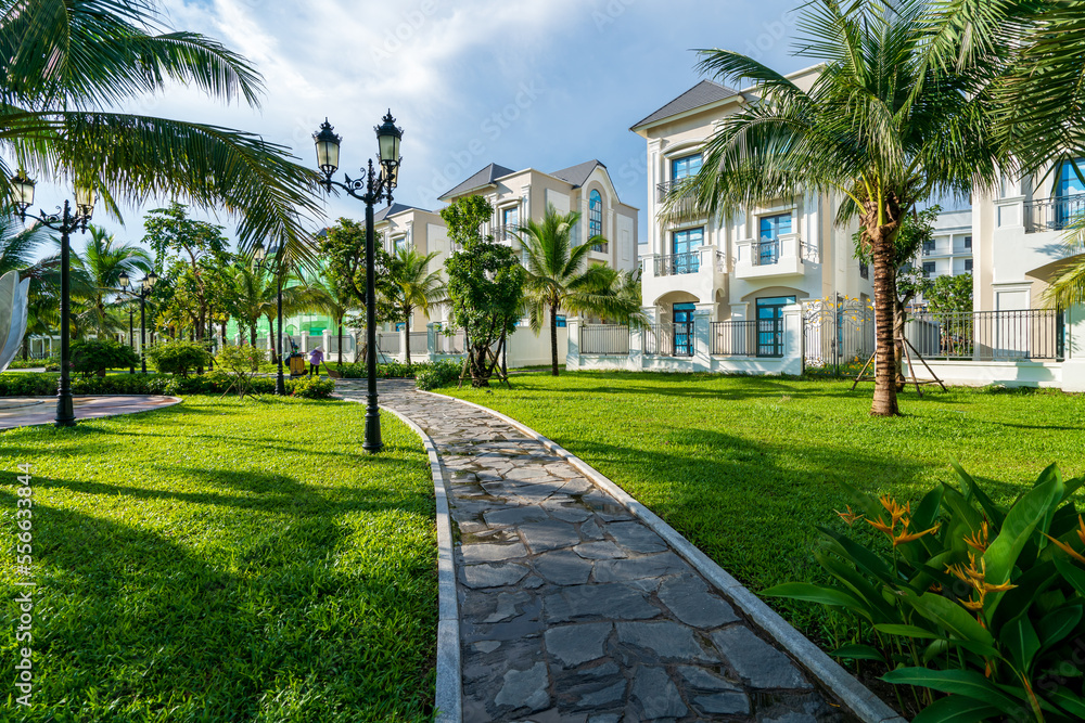 Public green park with modern blocks of flats and blue sky with white clouds in Vietnam Public green park with modern blocks of flats and blue sky with white clouds in Vietnam