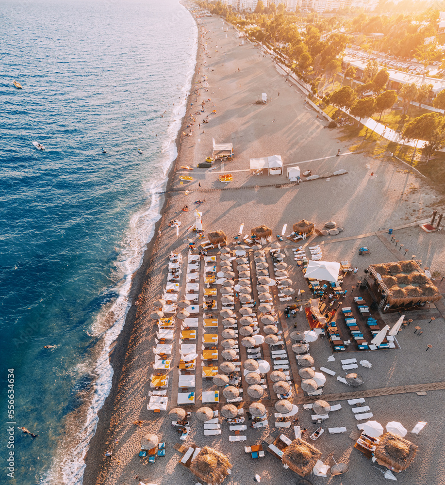 Obraz premium Aerial view of scenic and popular Konyaalti beach in Antalya resort town. Majestic mountains with haze in the background. Vacation and holiday in Turkiye