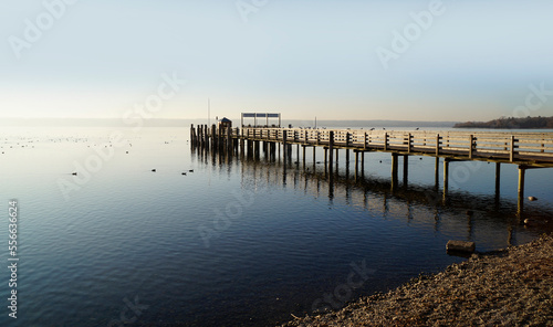 a long wooden pier in Herrsching on calm lake Ammersee in Bavaria on a clear serene January evening  Herrsching  Bavaria  Germany  
