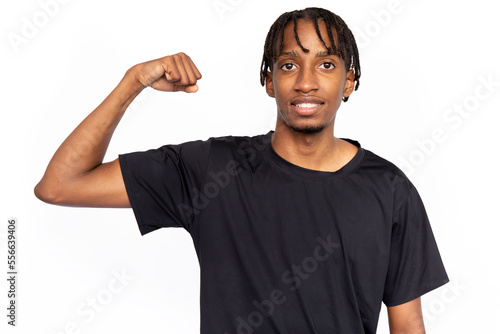 Confident young man showing his arm muscle. Male African American model with brown eyes and afro braids in black T-shirt demonstrating his bicep. Fitness, strength concept