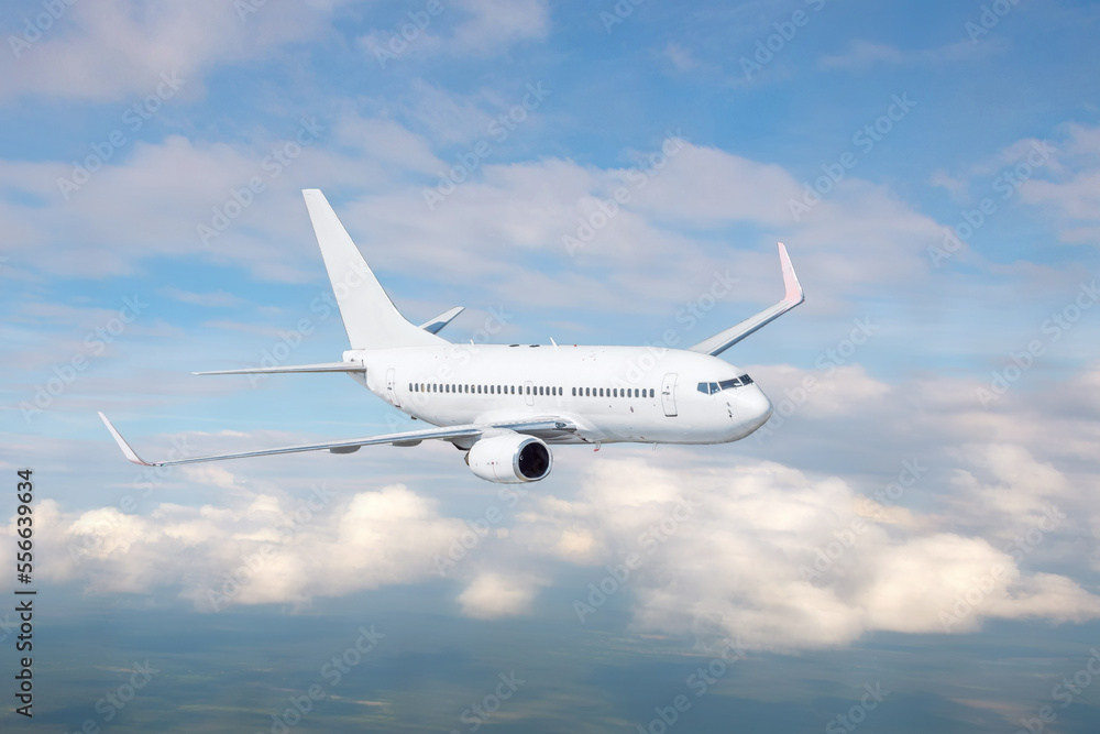 Obraz premium White passenger airplane flying in the sky amazing clouds in the background. Travel by air transport