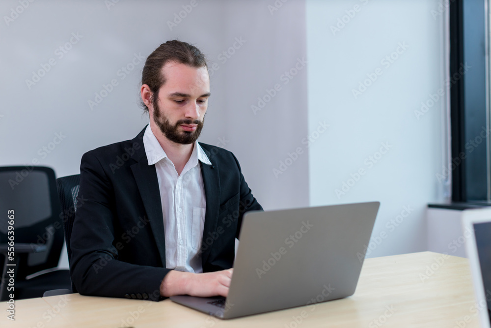 Business Man busy working on laptop computer at office. Businessman Using Laptop In Modern Office Business Man busy working on laptop computer at office. Businessman Using Laptop In Modern Office