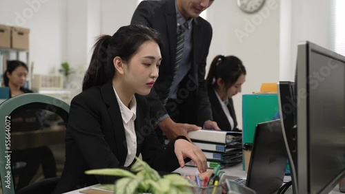 slow motion of tired chinese female employee overloaded with more work from her boss in the office. the heap of business assignment gives her headache