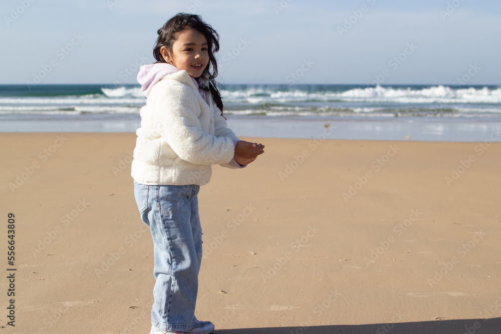 Portrait of smiling Asian girl on beach. Female model with dark hair and in white sweater smiling at camera. Portrait, beauty concept Portrait of smiling Asian girl on beach. Female model with dark hair and in white sweater smiling at camera. Portrait, beauty concept