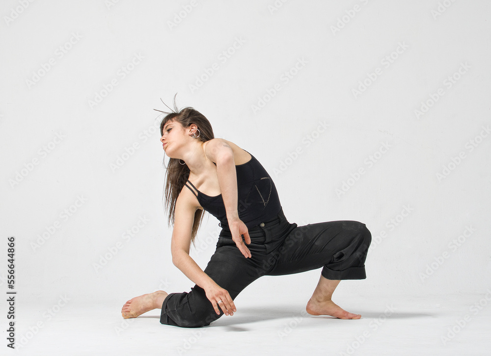 Professional female dancer performing in studio at a white wall Professional female dancer performing in studio at a white wall