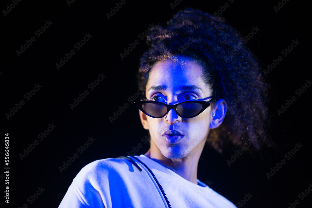Portrait of cool male dancer at night. Handsome African American man with curly hair in sunglasses. Portrait, beauty concept Portrait of cool male dancer at night. Handsome African American man with curly hair in sunglasses. Portrait, beauty concept