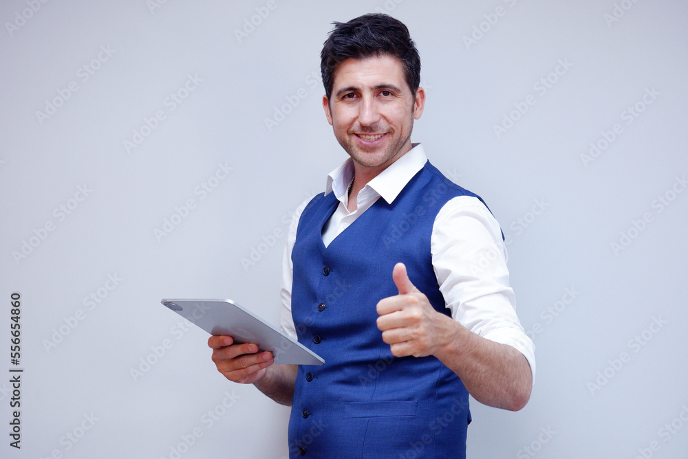 Businessman or young man in suit smiling holding tablet on white background. Businessman or young man in suit smiling holding tablet on white background.