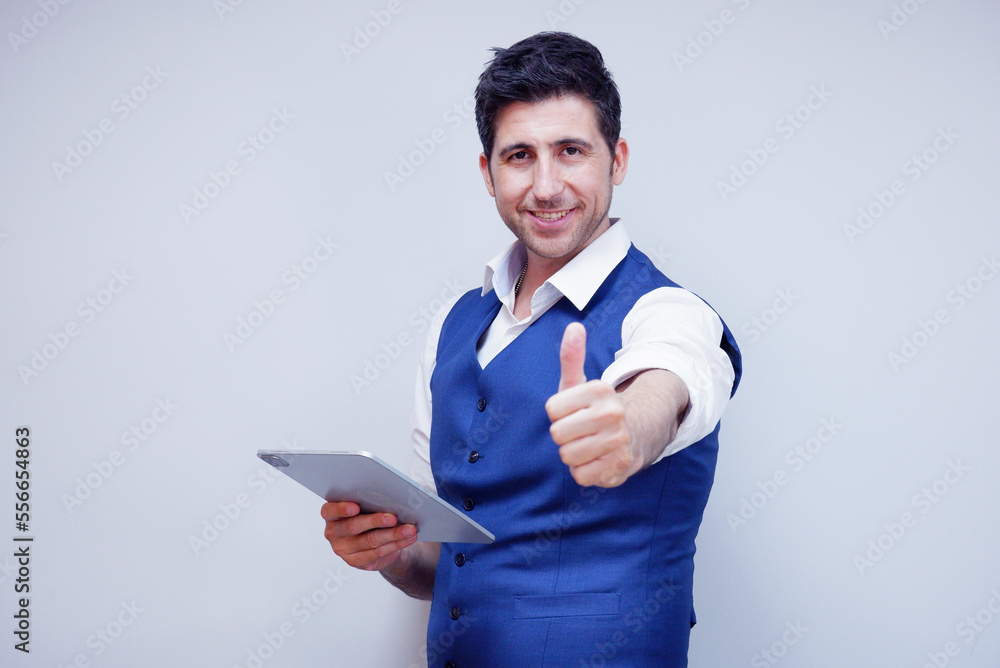Businessman or young man in suit smiling holding tablet on white background. Businessman or young man in suit smiling holding tablet on white background.