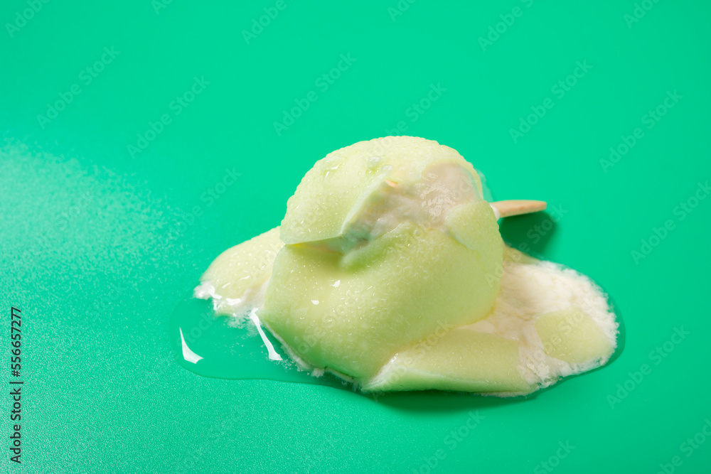 half melted green apple shape and flavor popsice on green background half melted green apple shape and flavor popsice on green background