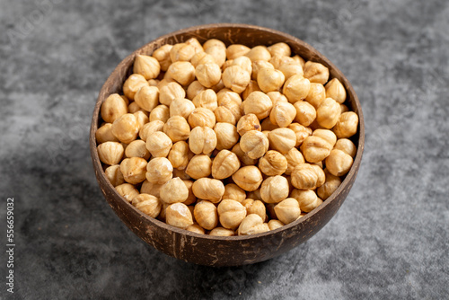 Roasted hazelnuts in bowl on dark background. Nuts in a coconut bowl. close up