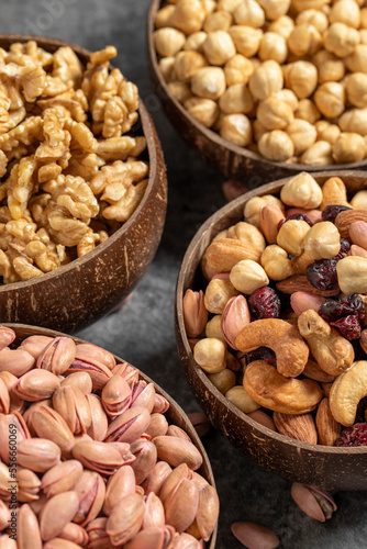 Walnuts, pistachios, hazelnuts and mixed nuts in a bowl on a dark background. Close up