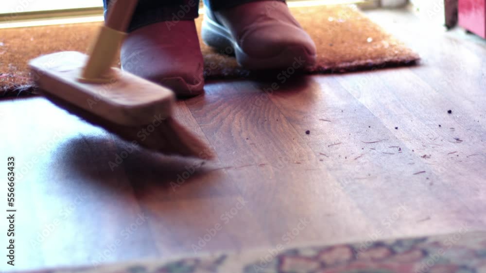 Using a broom to sweep door entrance Using a broom to sweep door entrance