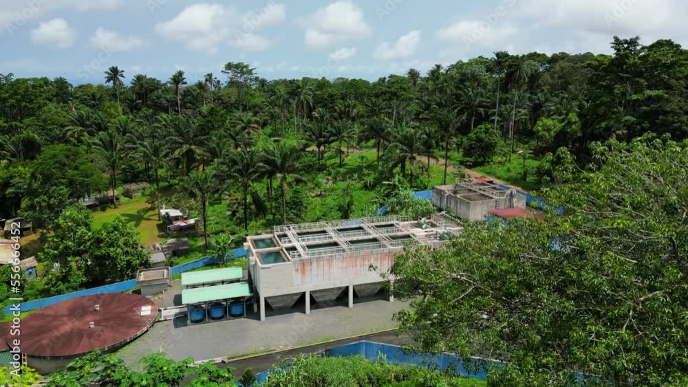 Aerial view around trees revealing a water treatment facility, in sunny Sao tome, Africa Aerial view around trees revealing a water treatment facility, in sunny Sao tome, Africa