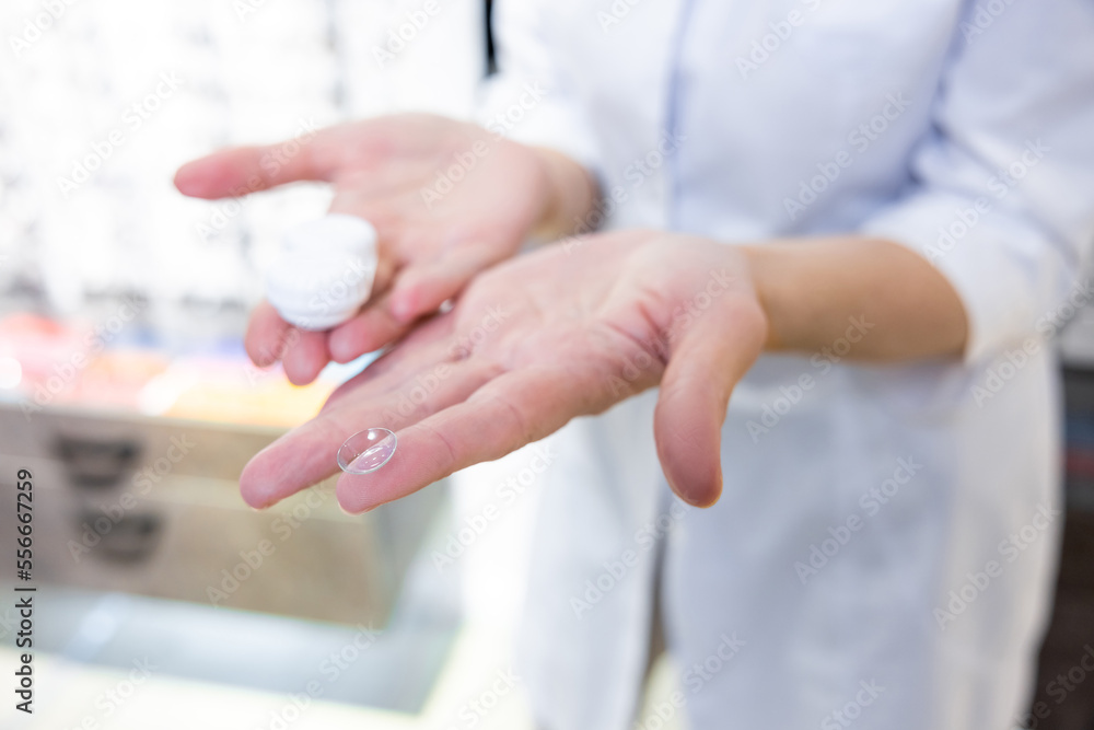 Close up of females hands holding contact lenses