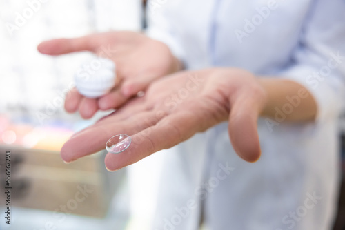 Close up of females hands holding contact lenses