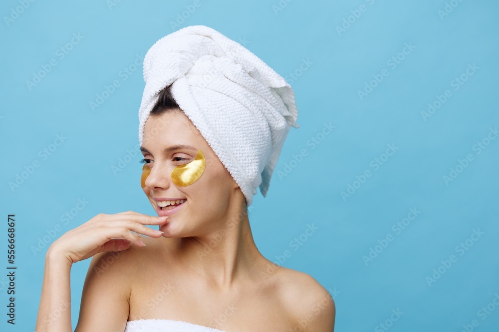 Horizontal photo, a woman with white skin on a blue background with a towel on her head and tele-care for her face in the morning with the best cosmetics. High quality photo Horizontal photo, a woman with white skin on a blue background with a towel on her head and tele-care for her face in the morning with the best cosmetics. High quality photo