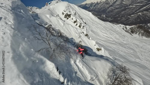 Sportsman skier extreme sport freeride downhill drop snow cornice mountain summit adrenaline race splash aerial view. FPV drone shot male ski professional athlete rider cliff valley sunny 50fps slo-mo