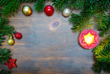Christmas background with decorations and red candle on wooden board