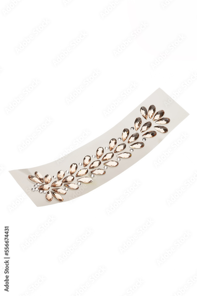 Close-up shot of a sheet of crystal stickers for body. The sheet of a self-adhesive jewel stickers is isolated on a white background. Top view. Close-up shot of a sheet of crystal stickers for body. The sheet of a self-adhesive jewel stickers is isolated on a white background. Top view.