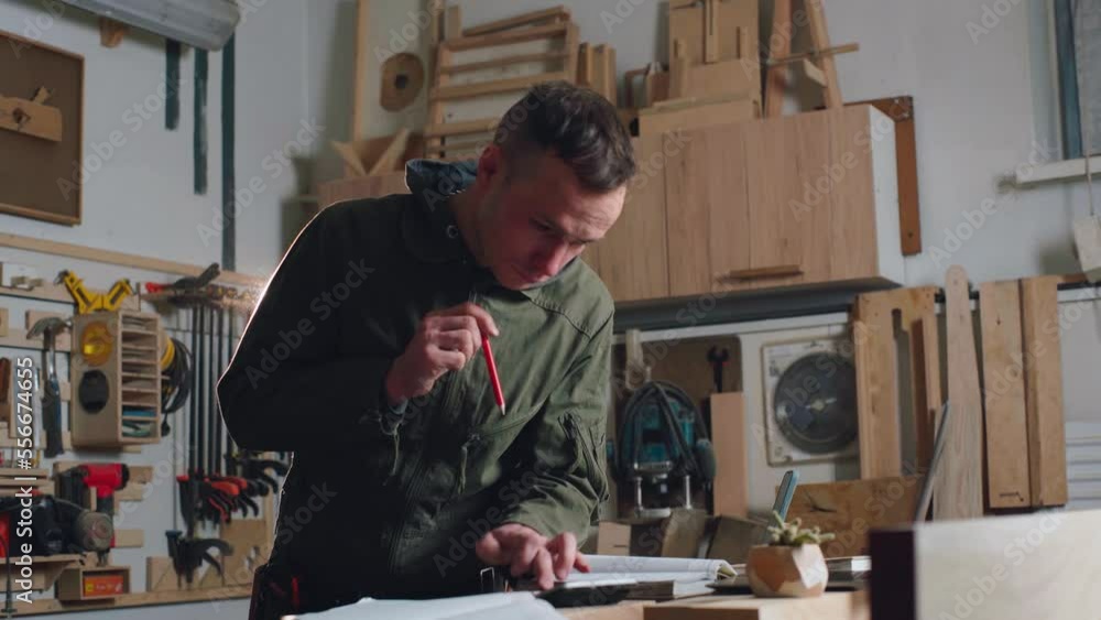Carpenter man calculates the cost of furniture for maximum monetary gain. Carpenter man calculates the cost of furniture for maximum monetary gain.