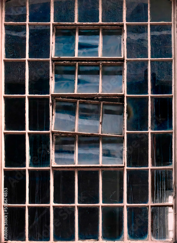 Old factory window texture with sky reflection, London, UK