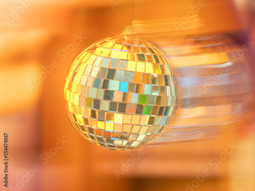 Disco ball on an orange background. Motion blur
