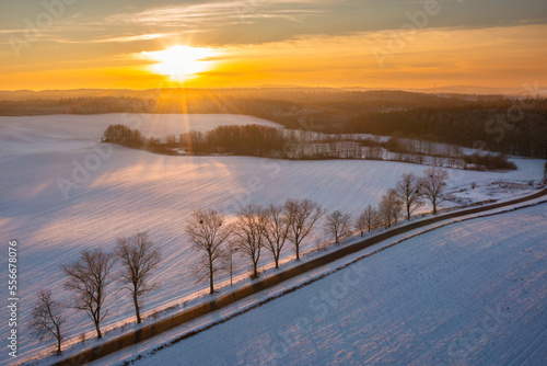 Snowy road in Kashubia at sunset, Poland