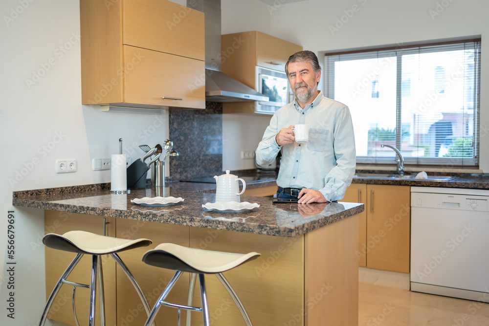 Senior white man having a cup of coffee in the kitchen at home and looking at the camera. Senior white man having a cup of coffee in the kitchen at home and looking at the camera.
