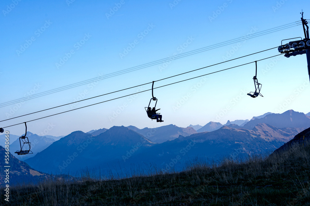 Chair lift at ski resort Axalp with tourists going up on a beautiful autumn morning view view over the Swiss Alps on a sunny autumn day. Photo taken October 18th, 2022, Axalp, Switzerland. Chair lift at ski resort Axalp with tourists going up on a beautiful autumn morning view view over the Swiss Alps on a sunny autumn day. Photo taken October 18th, 2022, Axalp, Switzerland.