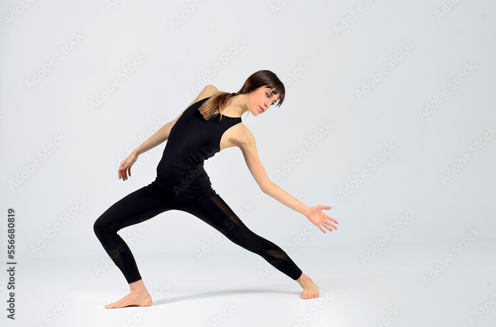 Young sporty yogi woman practicing yoga, doing Wild Thing, pose, working out, wearing sportswear, black pants and top, indoor full length, white yoga studio Young sporty yogi woman practicing yoga, doing Wild Thing, pose, working out, wearing sportswear, black pants and top, indoor full length, white yoga studio