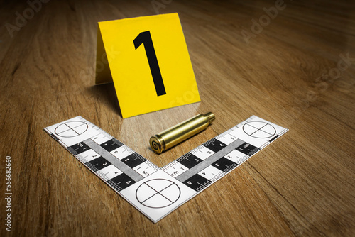 Crime Scene Investigation - .357 bullet casing as a piece of evidence placed with forensic ruler and yellow marker for documentation