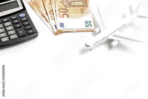 Airplane calculator and euro banknotes on a white background. Planning a vacation concept