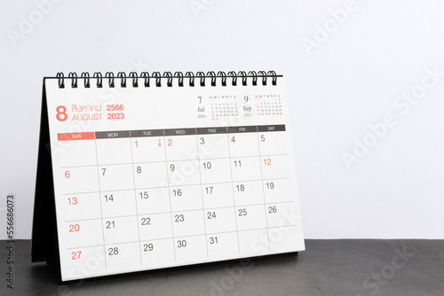 month August  2023 desk calendar for planners and reminders on a black table on a white background.
