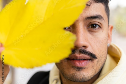 Hispanic man with autumn leaf photo