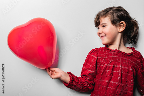 Happy girl holding red heart