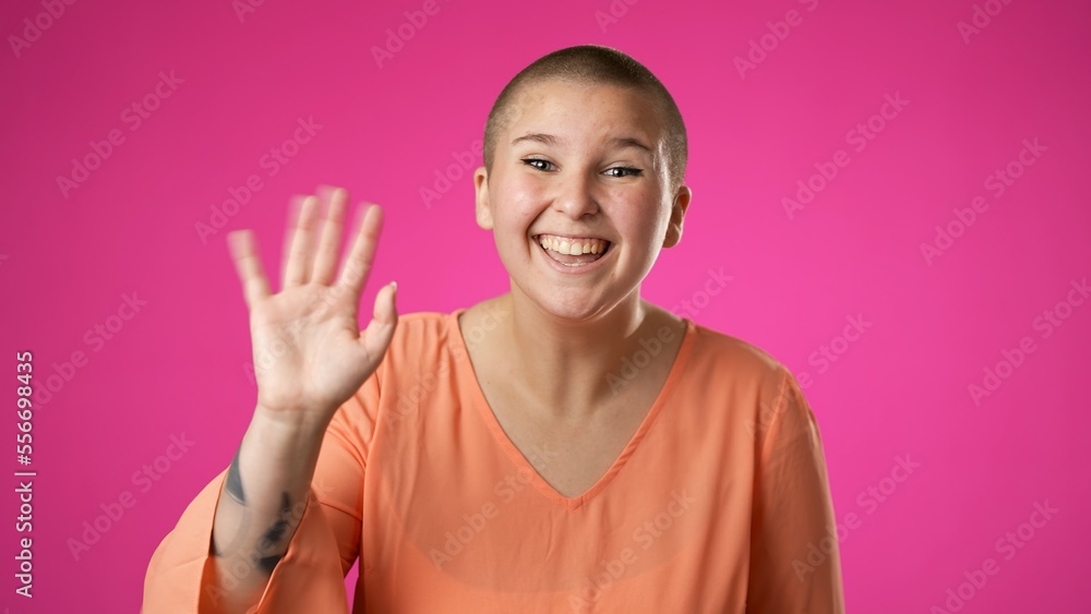 Happy gender fluid non binary young woman 20s video chatting, as seen from the pov point of view of the computer screen camera isolated on pink background. Happy gender fluid non binary young woman 20s video chatting, as seen from the pov point of view of the computer screen camera isolated on pink background.