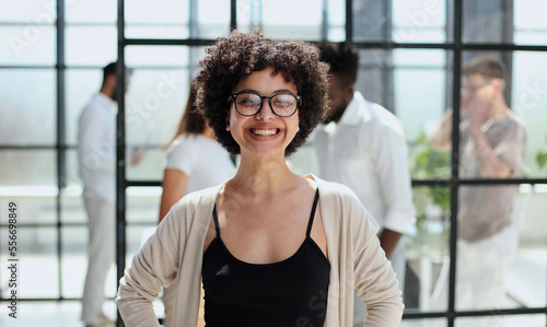 business woman with her staff in background at office